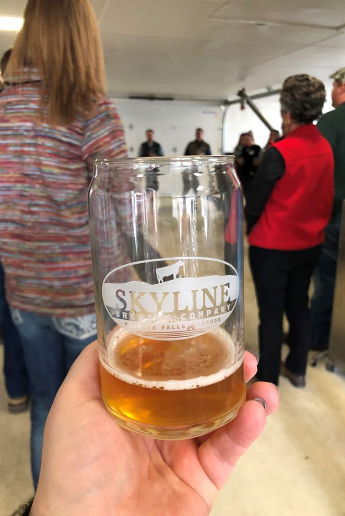 Holding a glass with Skyline Brewing Companies IPA.