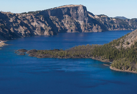 Wizard Island stands tall in the middle of the sparkling blue waters of Crater Lake National Park.